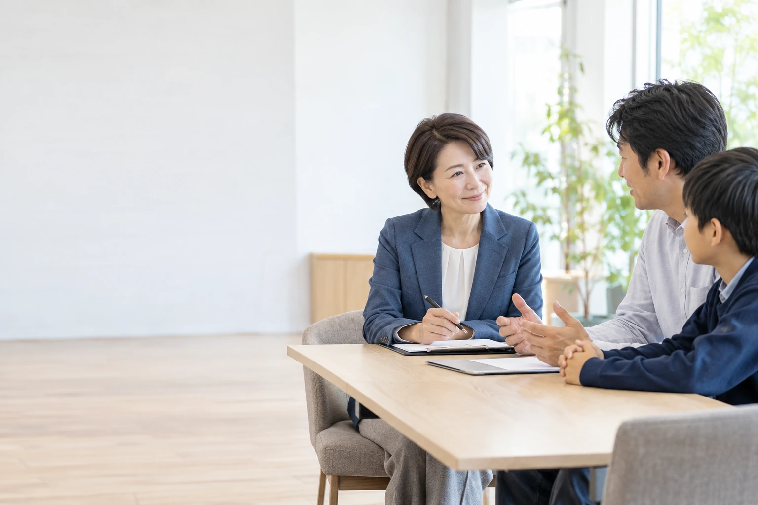 父親と男子生徒の話を聞く女性教育相談スタッフ