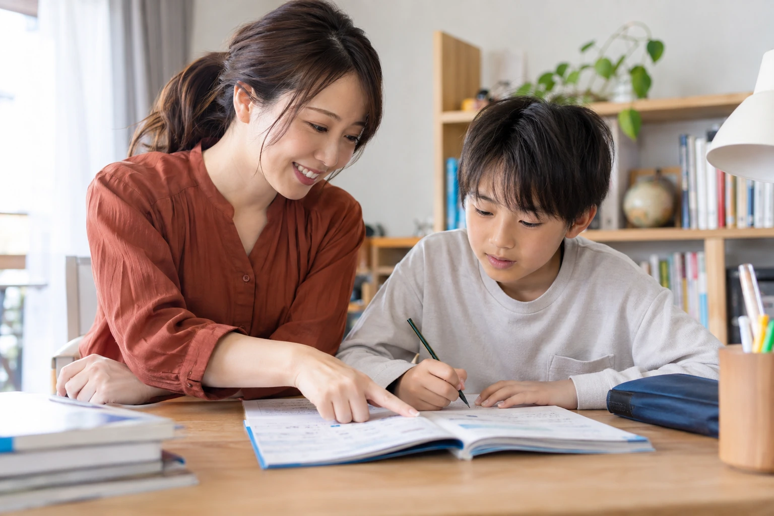 小学生の学習をワークブックで支える女性講師